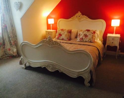 a bedroom with a large white bed with two lamps at The Royal Hotel Cromarty in Cromarty
