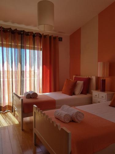 a bedroom with two beds and a window at Casa Da Ponte in Estói
