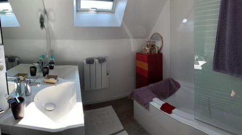 uma casa de banho branca com um lavatório e um chuveiro em Maison récente à 200m de la plage em Bernières-sur-Mer