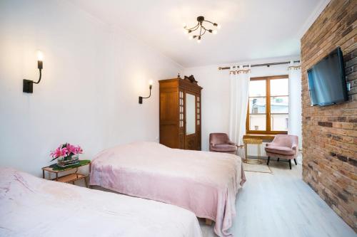 a bedroom with two beds and a brick wall at Apartamenty Magia in Lublin