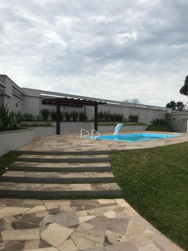a swimming pool with a bench on the grass at Villas Hotel in Santo Ângelo