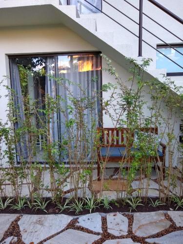 a window of a house with a bench and plants at Suítes Km18praia in Barra do Una