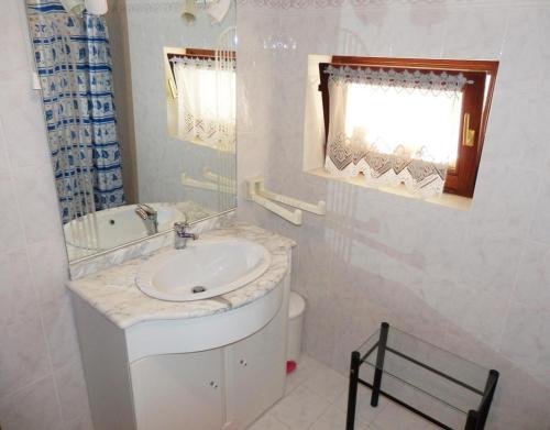 ein Bad mit einem Waschbecken, einem WC und einem Fenster in der Unterkunft Apartment Elida in Medulin