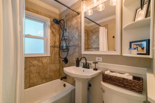 a bathroom with a sink and a toilet and a tub at Italian Style in Old Town with Private Hot Tub in Fort Collins