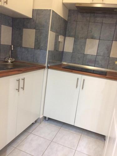 a kitchen with white cabinets and a sink at Baross-hat in Szolnok