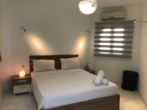 um quarto com uma cama branca e uma janela em Regency Towers Apartments em Hurghada
