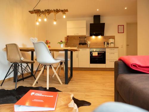 a kitchen and living room with a table and chairs at Black Forest Apartements by Hotel Grüner Baum Feldberg in Feldberg