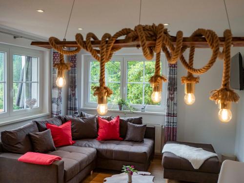 a living room with a brown couch and red pillows at Black Forest Apartements by Hotel Grüner Baum Feldberg in Feldberg