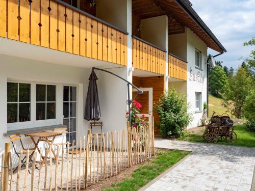 a patio with a table and an umbrella next to a house at Black Forest Apartements by Hotel Grüner Baum Feldberg in Feldberg