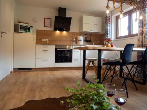 a kitchen with white cabinets and a table and chairs at Black Forest Apartements by Hotel Grüner Baum Feldberg in Feldberg