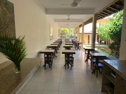 a row of tables and chairs in a restaurant at Praia da Ferradurinha Guest House in Búzios