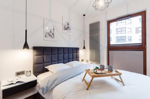 ein Schlafzimmer mit einem großen Bett und einem Tisch darauf in der Unterkunft Motlava Gdansk Apartment in Danzig