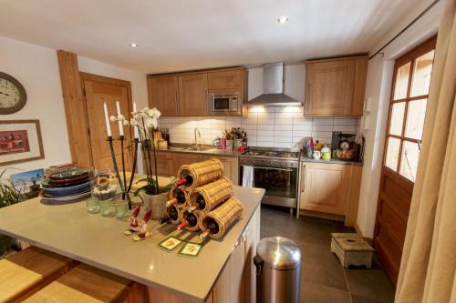 una cocina con armarios de madera y una mesa con toallas en The Guest House en Vallorcine