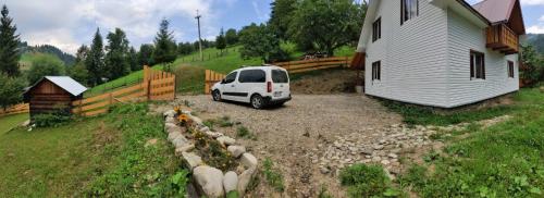 a white van parked in a driveway next to a house at Садиба "Ековид" in Krivorovnya