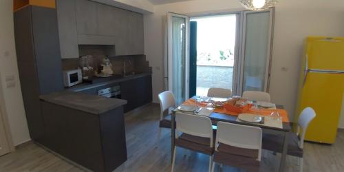 una cucina e una sala da pranzo con tavolo e sedie di B&B Hibiscus a Porto SantʼElpidio
