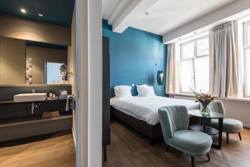 a bedroom with a bed and a table and a sink at Zakske13 - Design Boutique B&B in Bruges city centre in Bruges