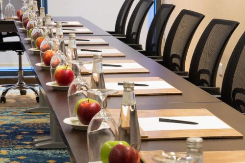 a long row of tables with bottles and apples on plates at Naviti Warwick Dammam in Dammam