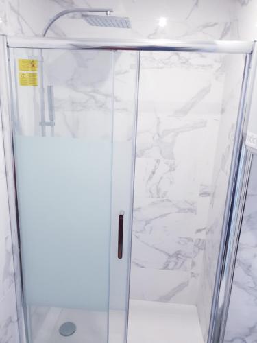 une douche avec une porte vitrée dans une salle de bain dans l'établissement All-In-One hyper centre La Rochelle, à La Rochelle