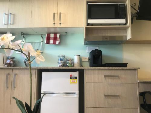 a kitchen with a white refrigerator and a microwave at Randwick City Lodge 2 in Sydney