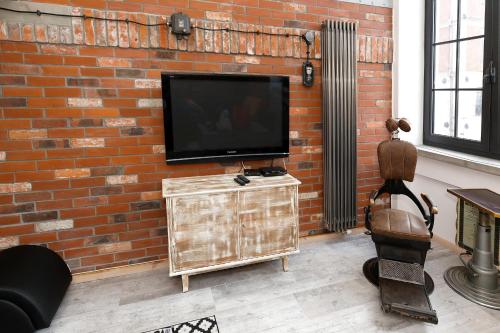 a brick wall with a flat screen tv on it at Loft Szpularnia in Żyrardów