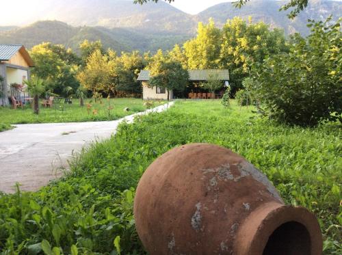 a large rusted object in the grass next to a road at Taripiri in Ambrolauri