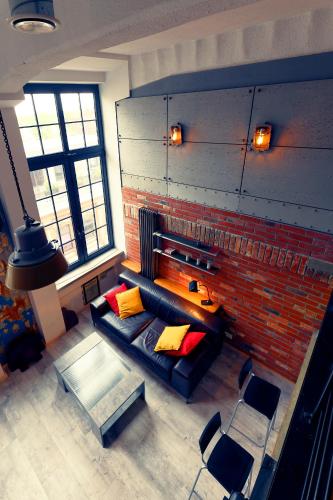 a living room with a couch and a brick wall at Loft Szpularnia in Żyrardów