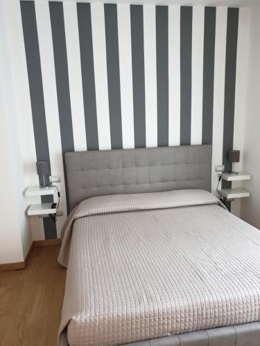 een slaapkamer met een bed met een gestreepte muur bij B&B IN CENTRO in Isernia