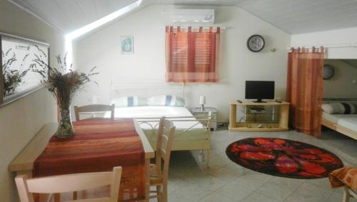 a living room with a dining room table and a bedroom at Apartments Jozefina in Crikvenica