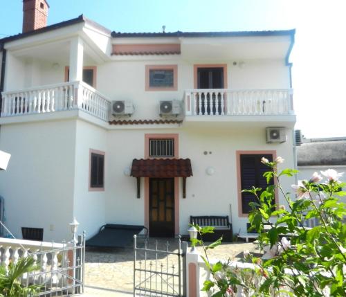 a large white house with a balcony at Apartments Jozefina in Crikvenica