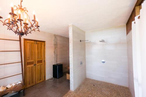 a hallway with a door and a chandelier at Punta Duarte Garden Inn in Los Duarte