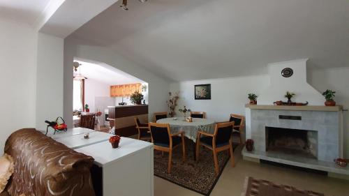 ein Wohnzimmer mit einem Sofa, einem Tisch und einem Kamin in der Unterkunft Къща за Гости Солакови ** in Dewin