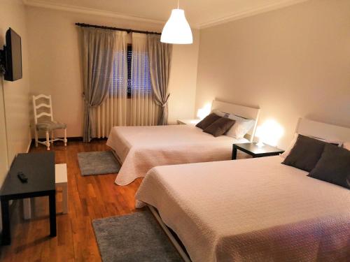 a hotel room with two beds and a window at Casa de Agrelos in Ponte da Barca