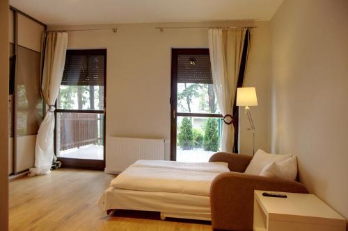 シュクラルスカ・ポレンバにあるPanorama Górのベッドルーム1室(ベッド1台、ソファ、窓付)