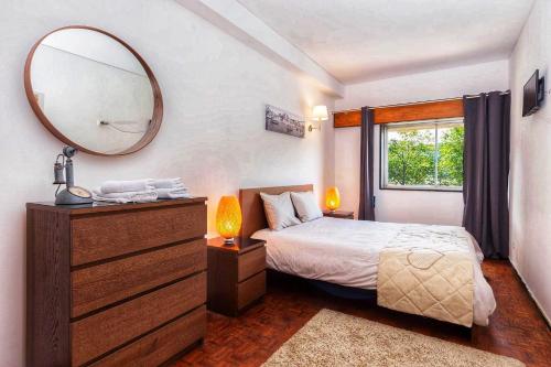 a bedroom with a bed with a mirror and a dresser at Mar Azul Apartamento Al in Porto