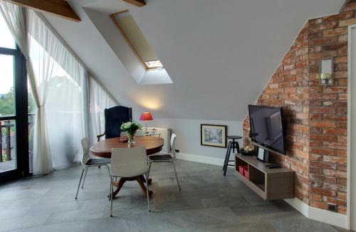 a living room with a table and a tv at Apartamentowiec Panorama Gór City Center Family&Pet-friendly in Szklarska Poręba