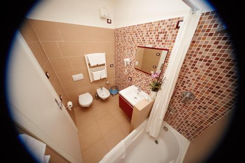 bagno con vasca, lavandino e servizi igienici di Hotel Residence Key Club a Montalto di Castro