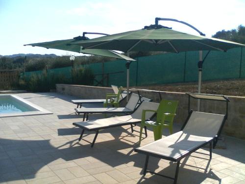 a group of chairs and an umbrella next to a pool at Agriturismo Villalta in Ponte Felcino