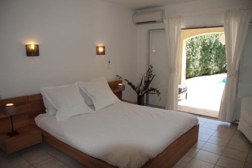 a bedroom with a bed and a large window at Villa Hortense - Golf of Saint Tropez in Sainte-Maxime