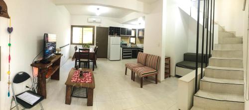 a living room with a staircase and a kitchen at Dúplex Confort in Posadas