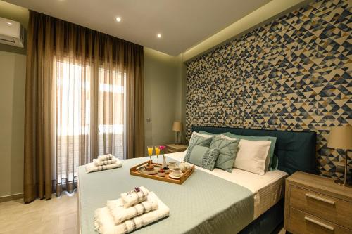a bedroom with a bed with towels on it at Sunny Luxury Suite Grey in Kavála