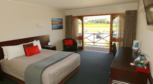 a hotel room with a bed and a balcony at The Harvest Hotel in Cromwell