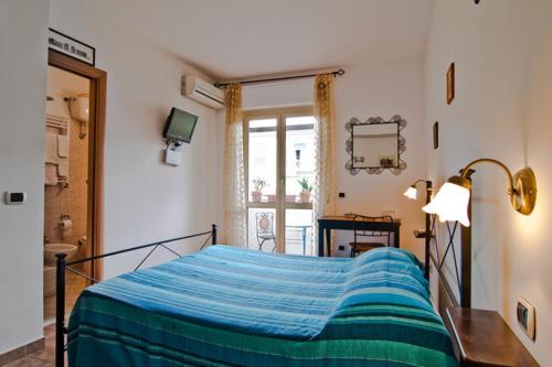 a bedroom with a bed and a lamp and a window at B&B Acquedotti Antichi in Rome