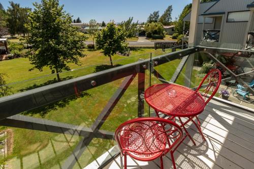 two chairs and a table on a balcony at ASURE Explorer Motel & Apartments in Te Anau