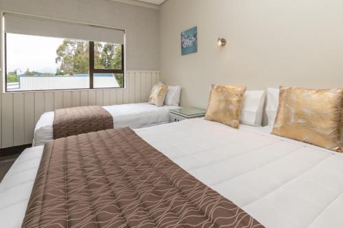 a bedroom with two beds and a window at ASURE Explorer Motel & Apartments in Te Anau
