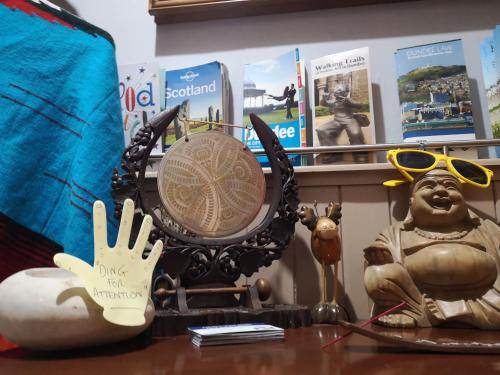 a table with a clock and a statue on it at aabAlree Guest House in Dundee