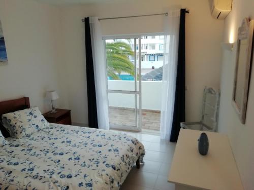 a bedroom with a bed and a sliding glass door at Jasmim in Lagos