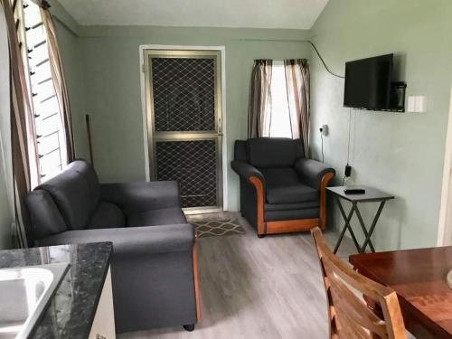 uma sala de estar com um sofá e uma cadeira em Lotopa Tiny House em Lepea