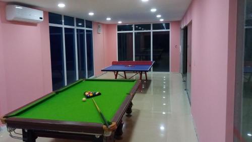 a green pool table in a room with pink walls at Residences Sommet Port Salut in Port-Salut