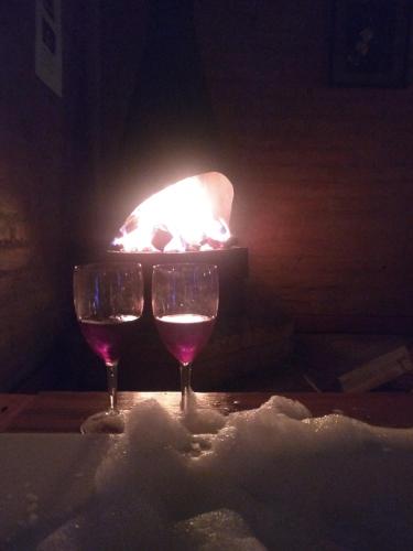 two glasses of wine in front of a fireplace at Pousada Vale Monte Azul in Santo Antônio do Pinhal