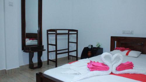 a bedroom with a bed with pink towels on it at Lavender Home Yala Safari in Tissamaharama